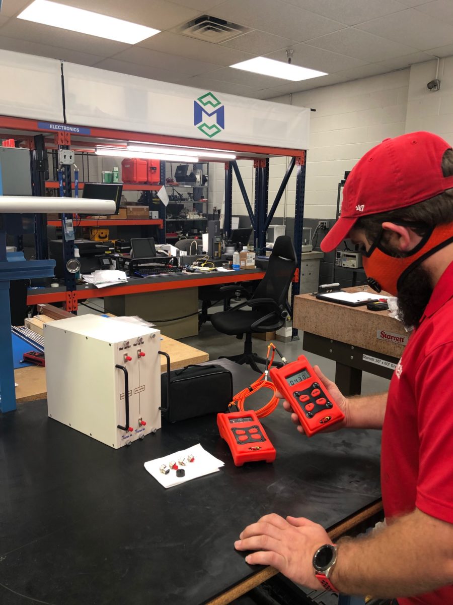 A Michelli Weighing & Measurement technician performs calibration on fiber optic equipment