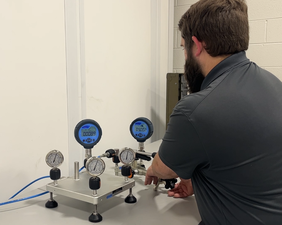 A Michelli Weighing & Measurement technician performs calibration on pressure gauges